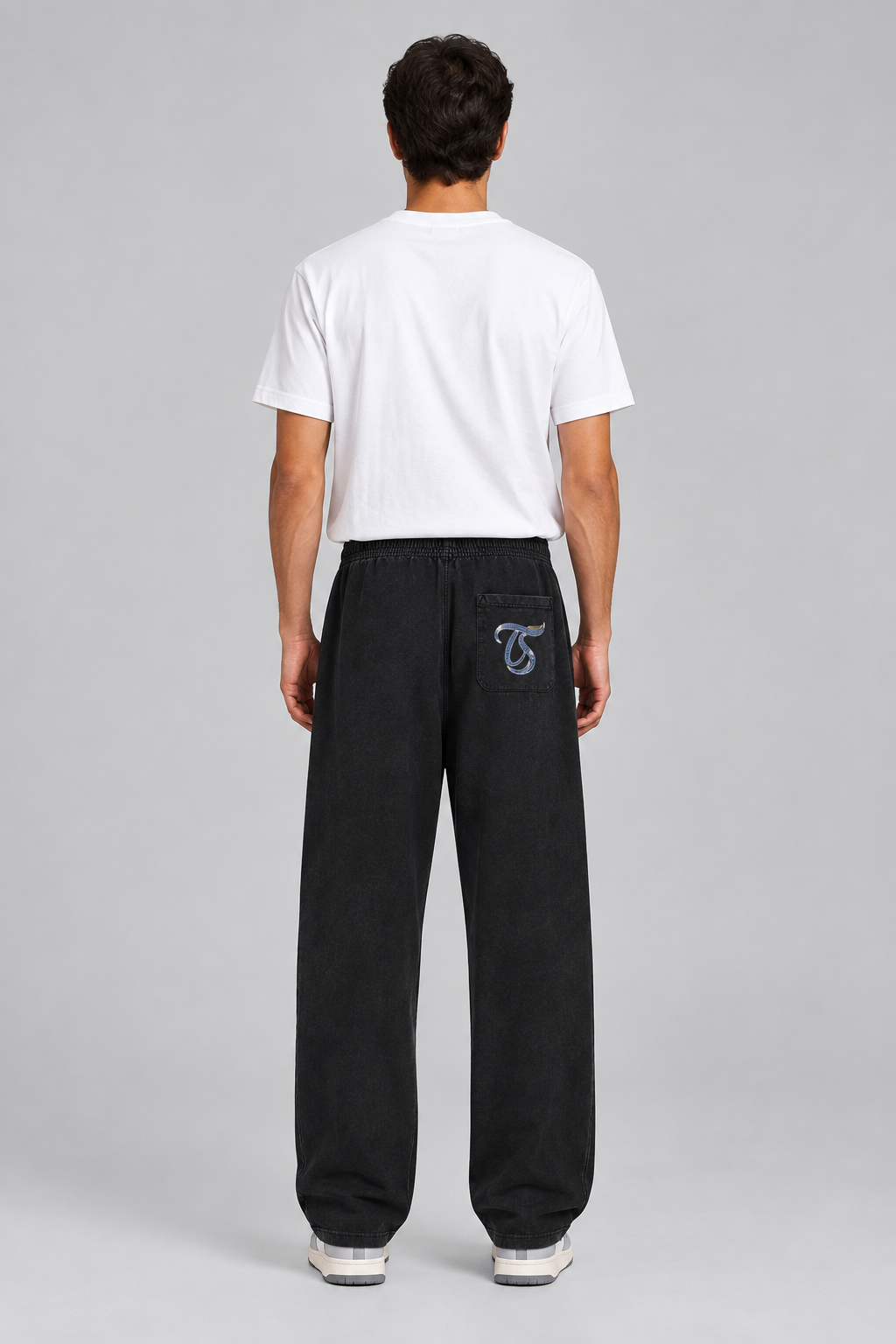 Male model wearing black Leo mineral wash straight sweatpants, back view TS pocket mark; illustrative print
