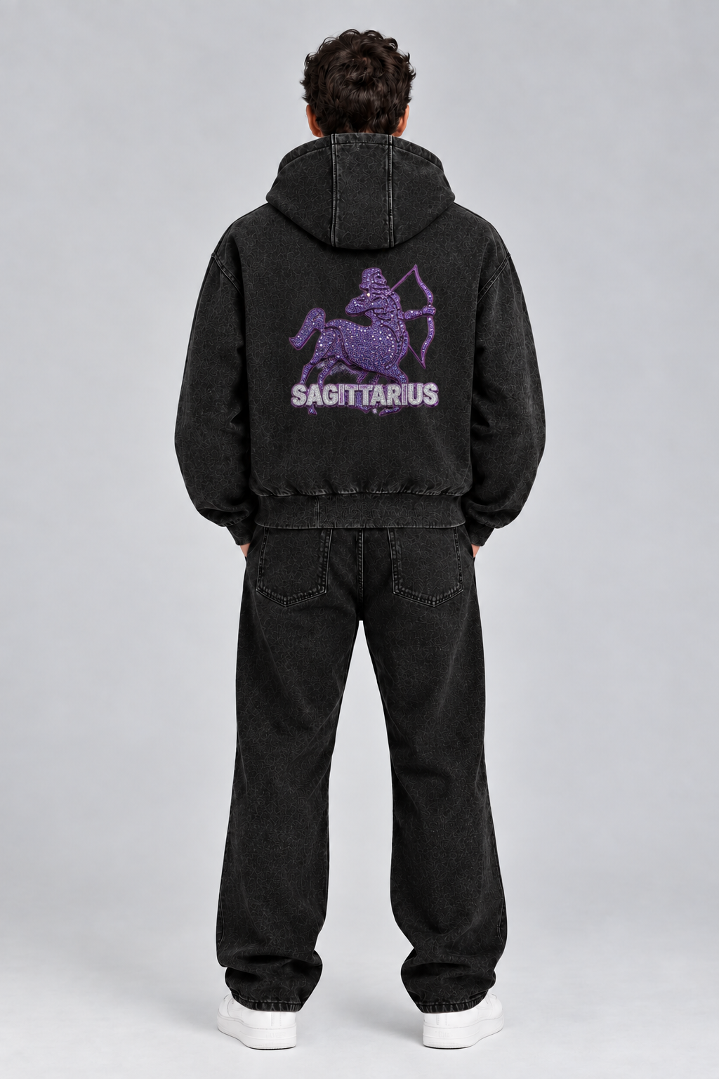 Male model wearing black Sagittarius vintage wash full zip hoodie, back view; print is illustrative