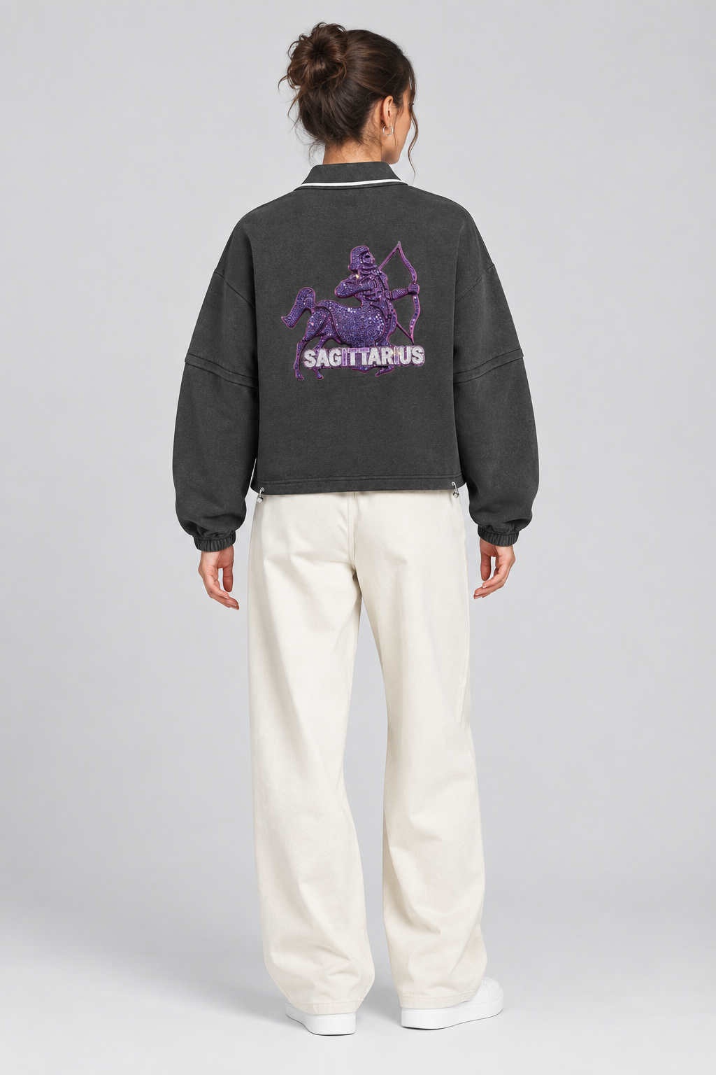 Female model wearing Sagittarius unisex boxy collared detachable sweatshirt with archer artwork, back view; illustrative styling image