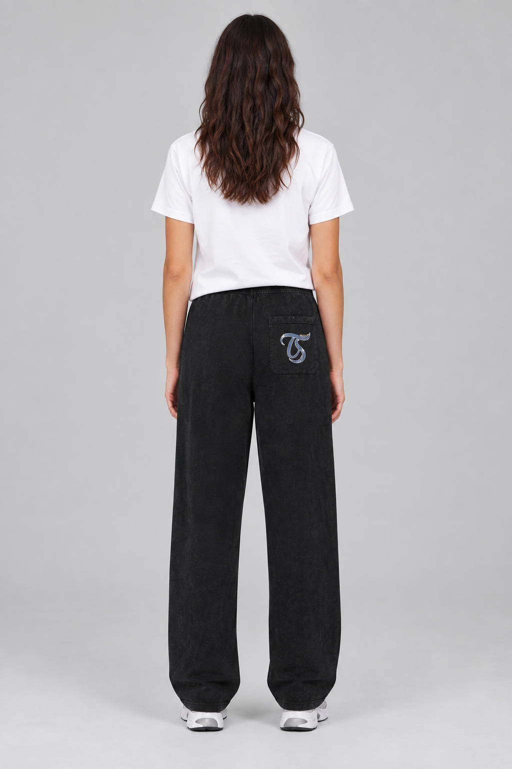Female model wearing black Scorpio mineral wash straight sweatpants, back TS pocket mark; illustrative print