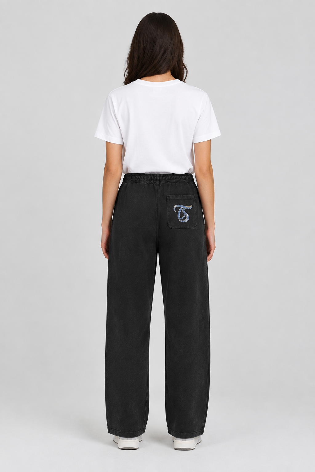 Female model wearing black Capricorn mineral wash straight sweatpants, back TS pocket mark; illustrative print