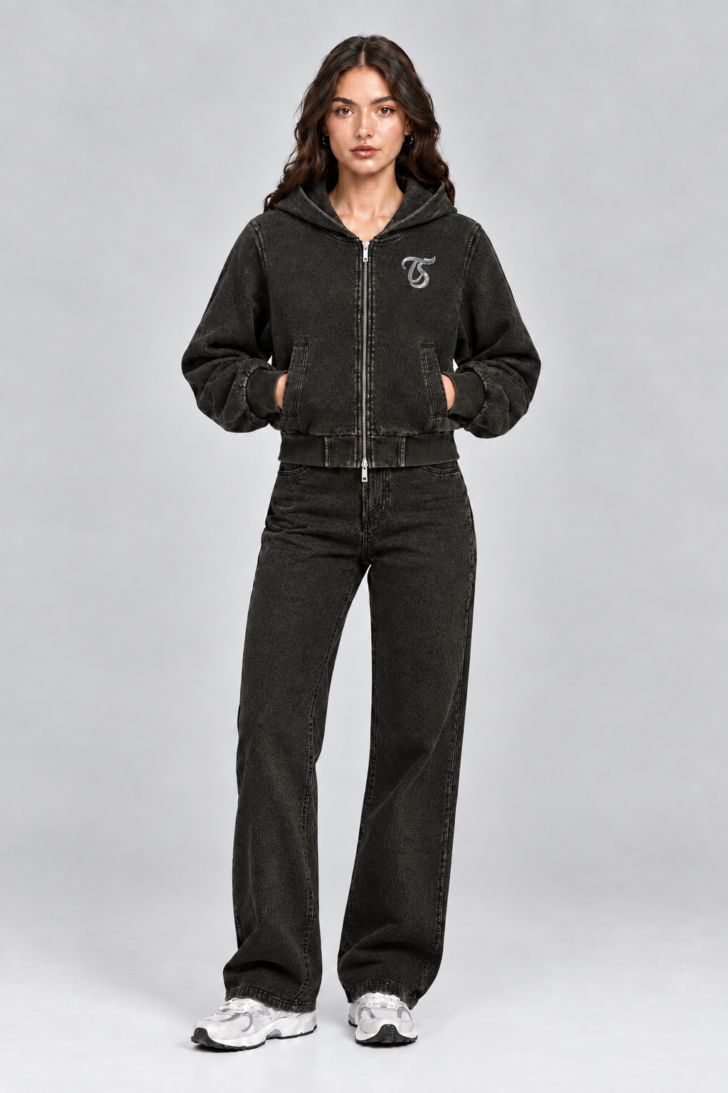 Female model wearing black Leo vintage wash full zip hoodie with TS logo, front view; print is illustrative