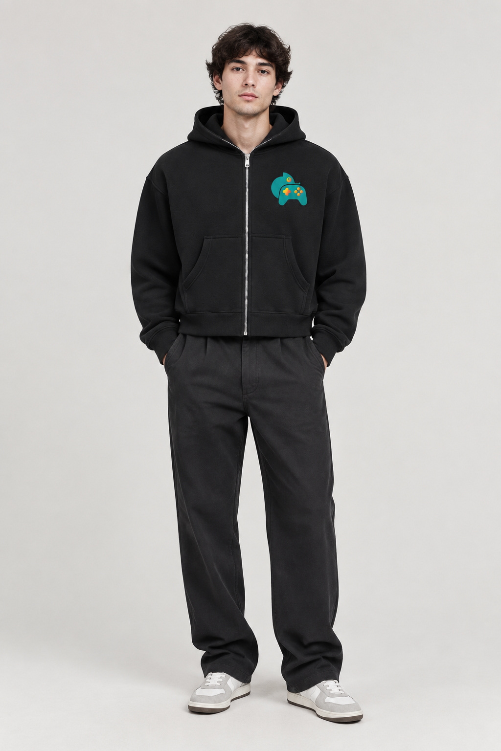 Front view of model wearing black fleeced full-zip boxy hoodie with teal chest graphic