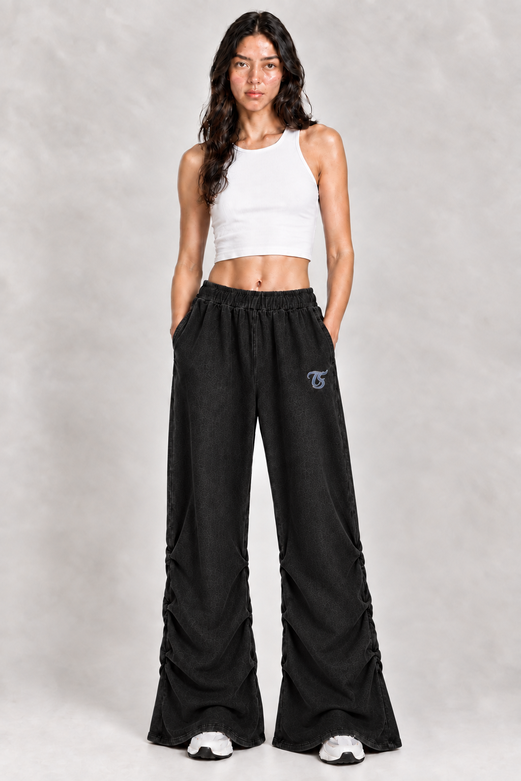 Female model wearing black Libra vintage wash ruched sweatpants with TS logo, front view