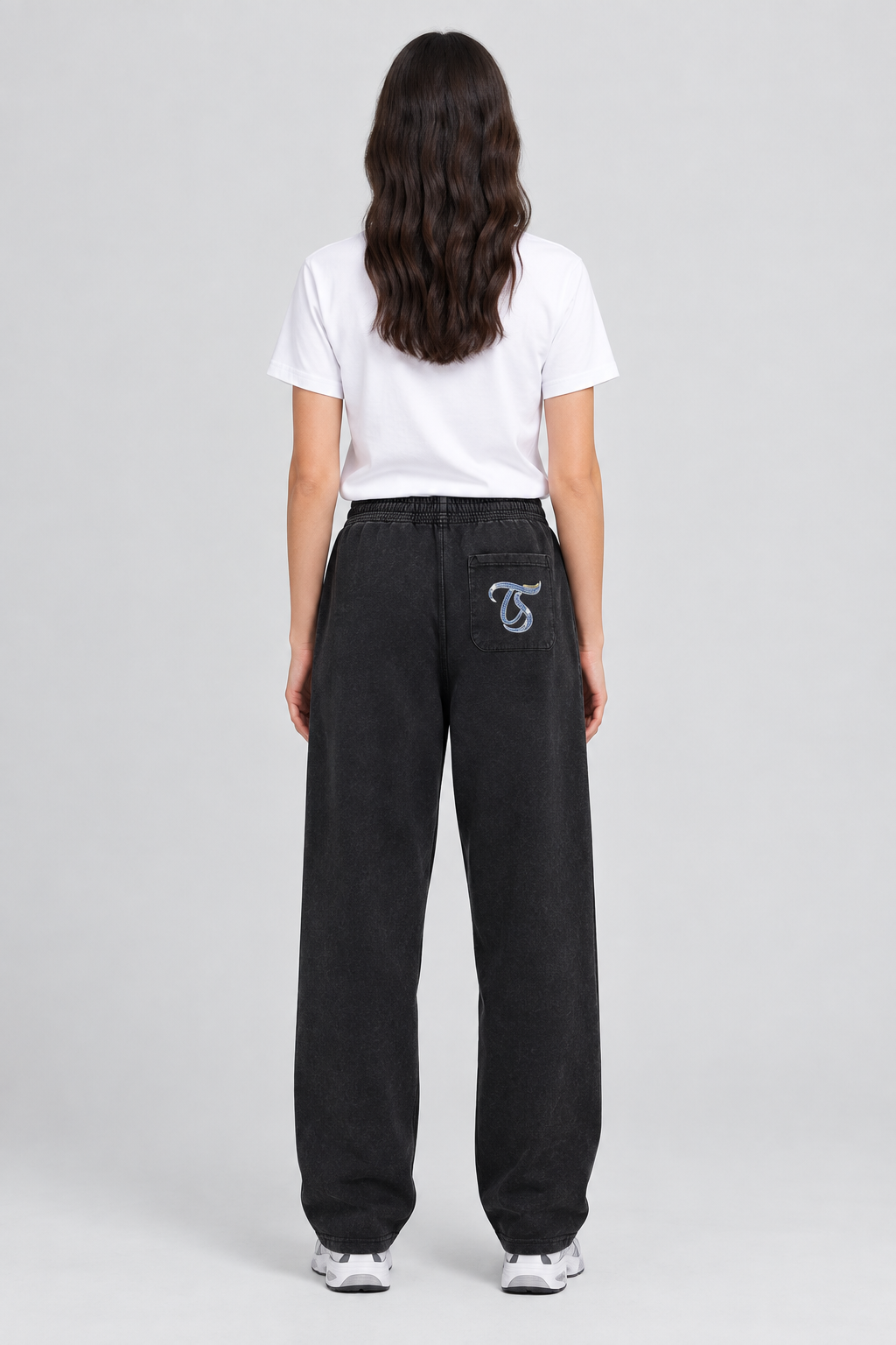 Female model wearing black Cancer mineral wash straight sweatpants, back view with TS pocket mark; illustrative print