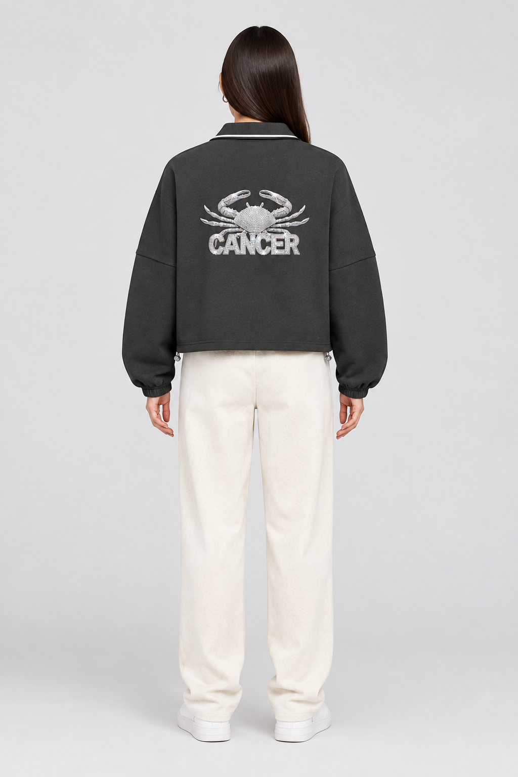 Female model wearing Cancer unisex boxy collared detachable sweatshirt with crab graphic, back view; illustrative styling image