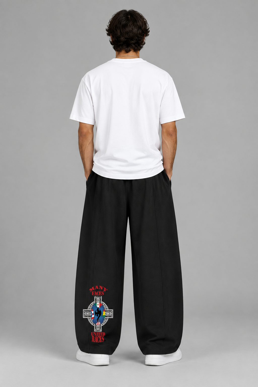 Model wearing black heavyweight wide leg panel sweatpants, back with decorative leg artwork; illustrative styling photo