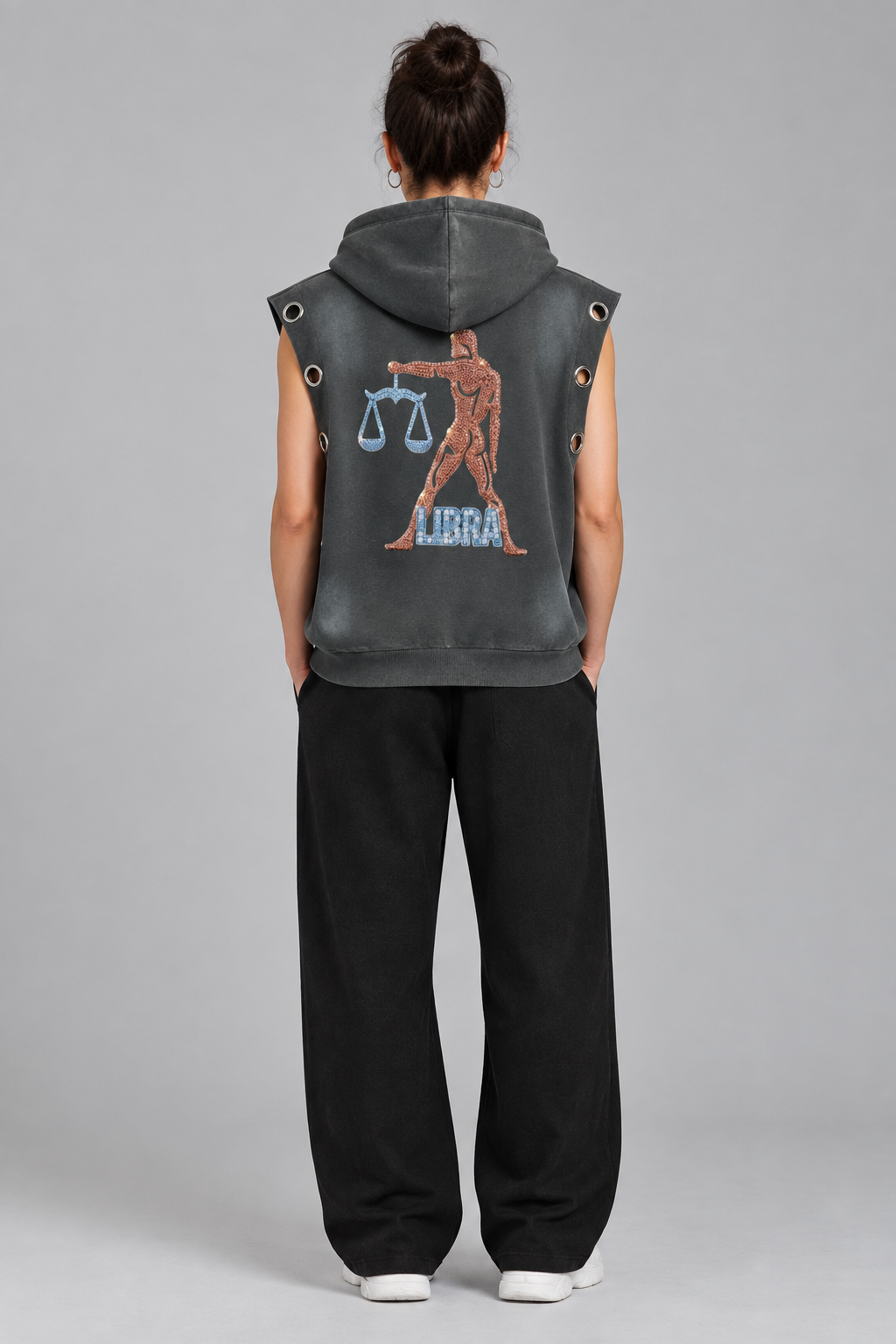 Female model wearing gray Libra sun fade sleeveless hoodie, back scales artwork; illustrative styling photo