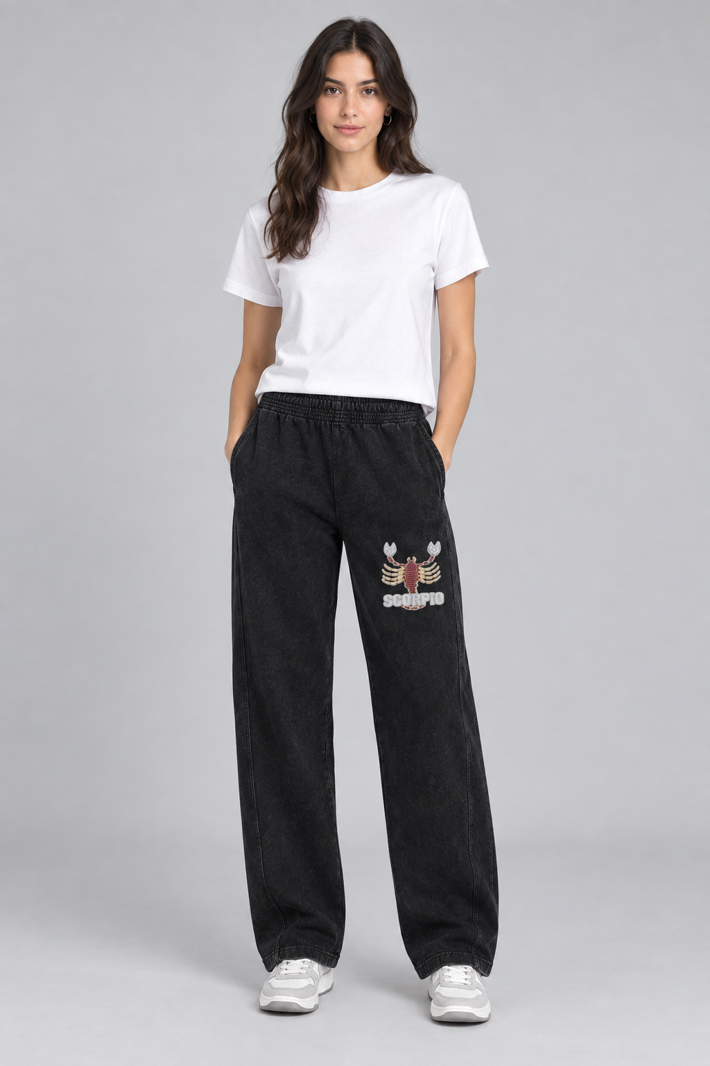 Female model wearing black Scorpio mineral wash straight sweatpants with scorpion front thigh design; illustrative print