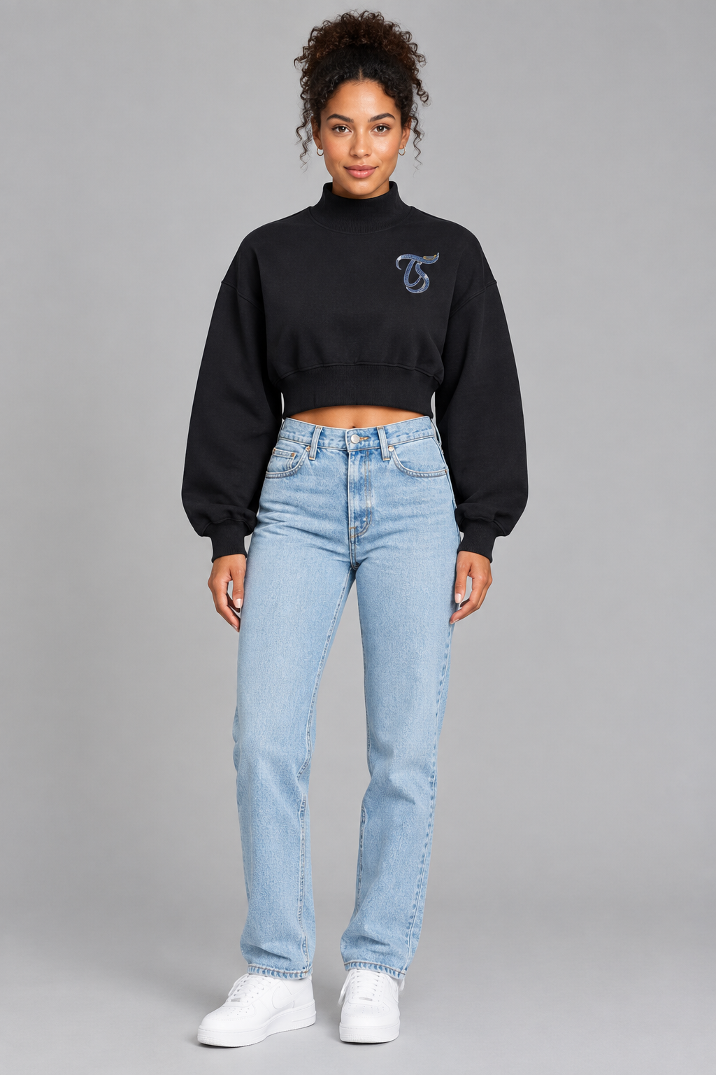 Female model in black Aquarius women's crop mock neck sweatshirt, front TS chest mark; illustrative print