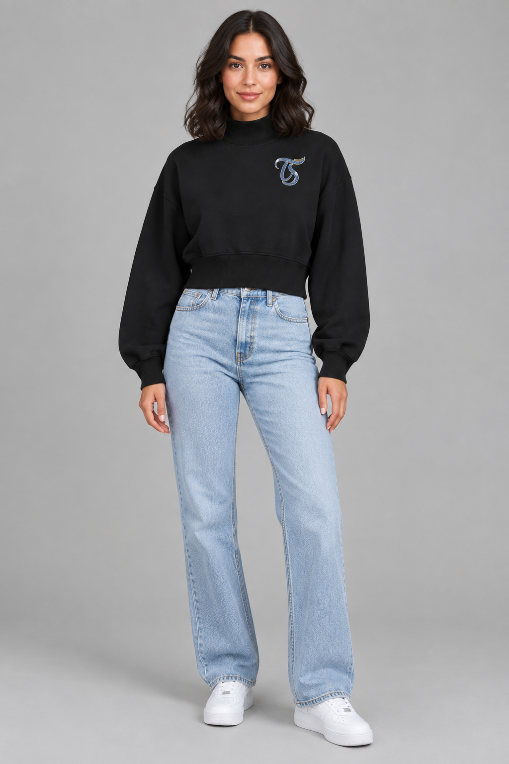 Female model in black Capricorn women's crop mock neck sweatshirt, front TS chest mark; illustrative print