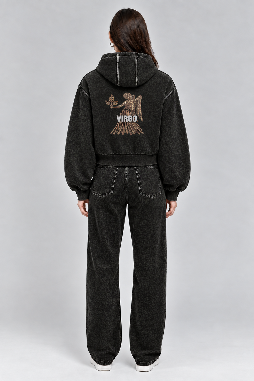 Female model wearing black Virgo vintage wash full zip hoodie, back view; print is illustrative