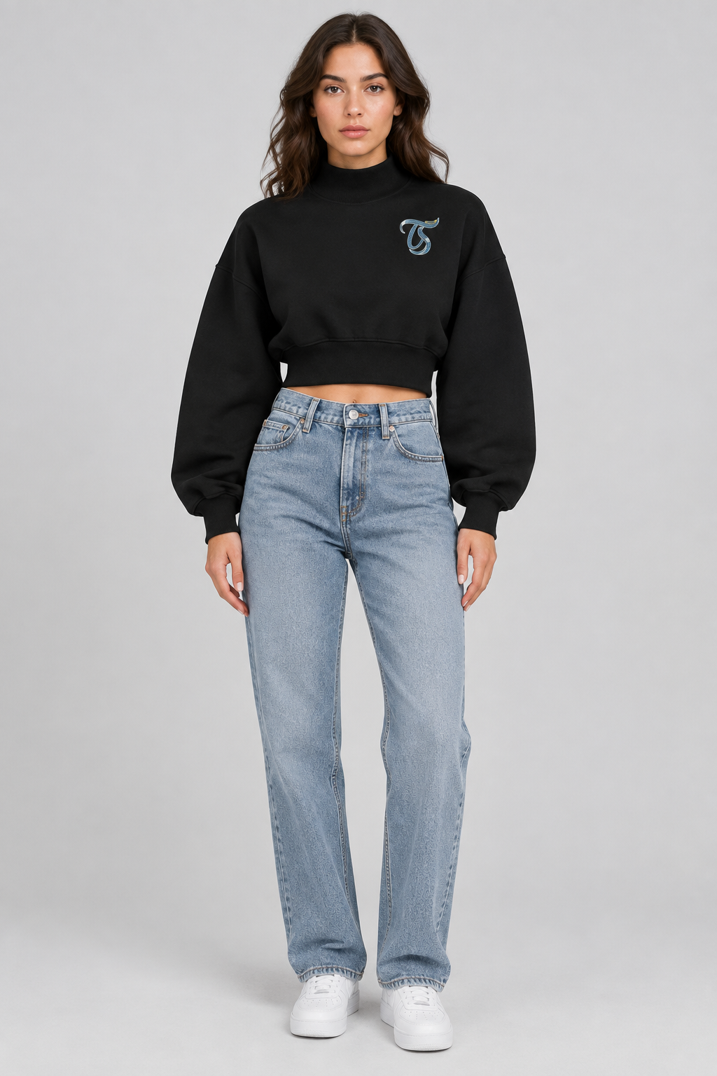 Female model in black Aries women's crop mock neck sweatshirt, front with TS logo; illustrative print