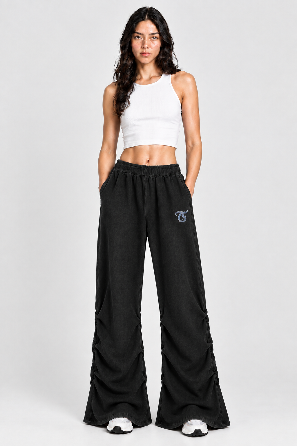 Female model wearing black Sagittarius vintage wash ruched sweatpants with TS logo, front view