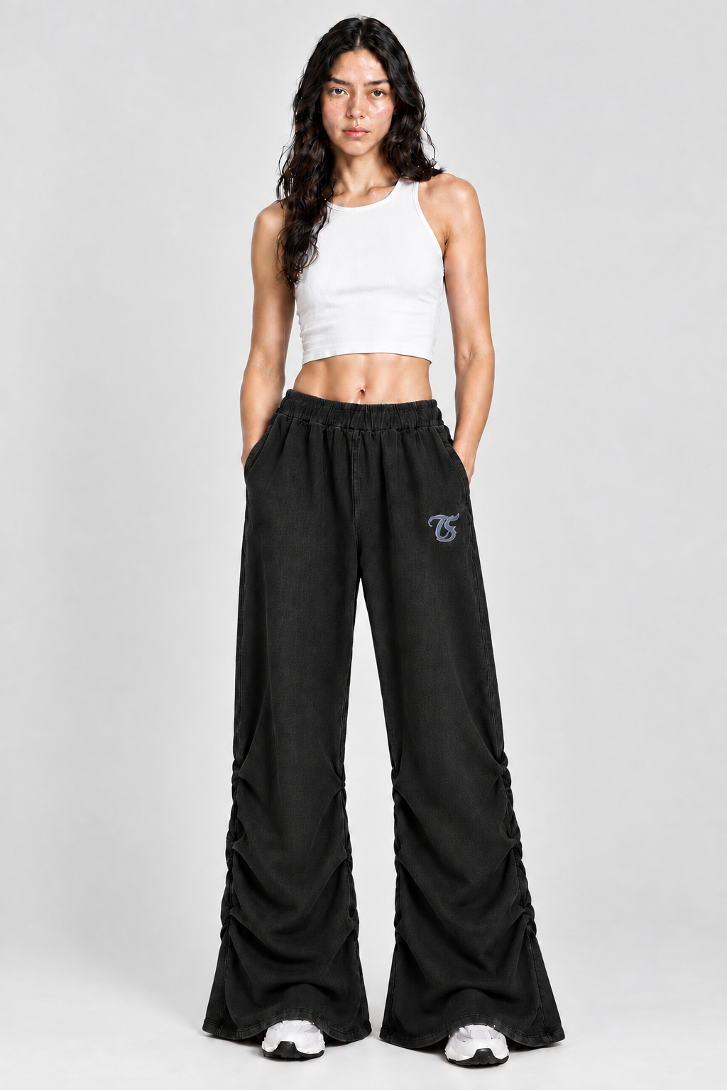 Female model wearing black Capricorn vintage wash ruched sweatpants with TS logo, front view