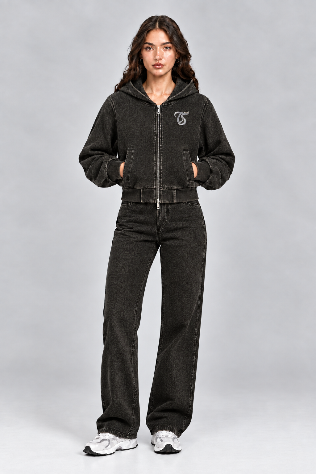 Female model wearing black Virgo vintage wash full zip hoodie with TS logo, front view; print is illustrative