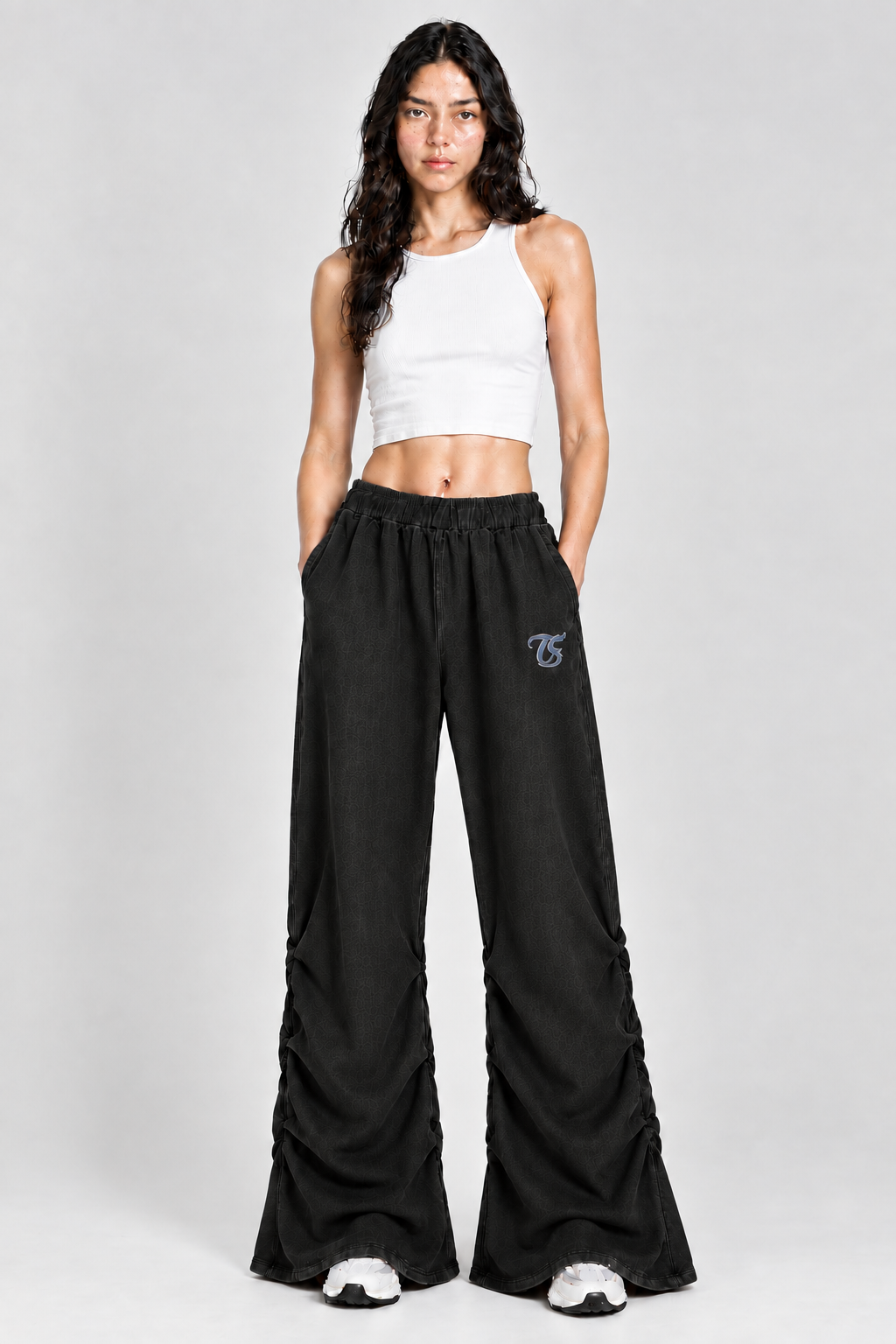 Female model wearing black Aquarius vintage wash ruched sweatpants with TS logo, front view