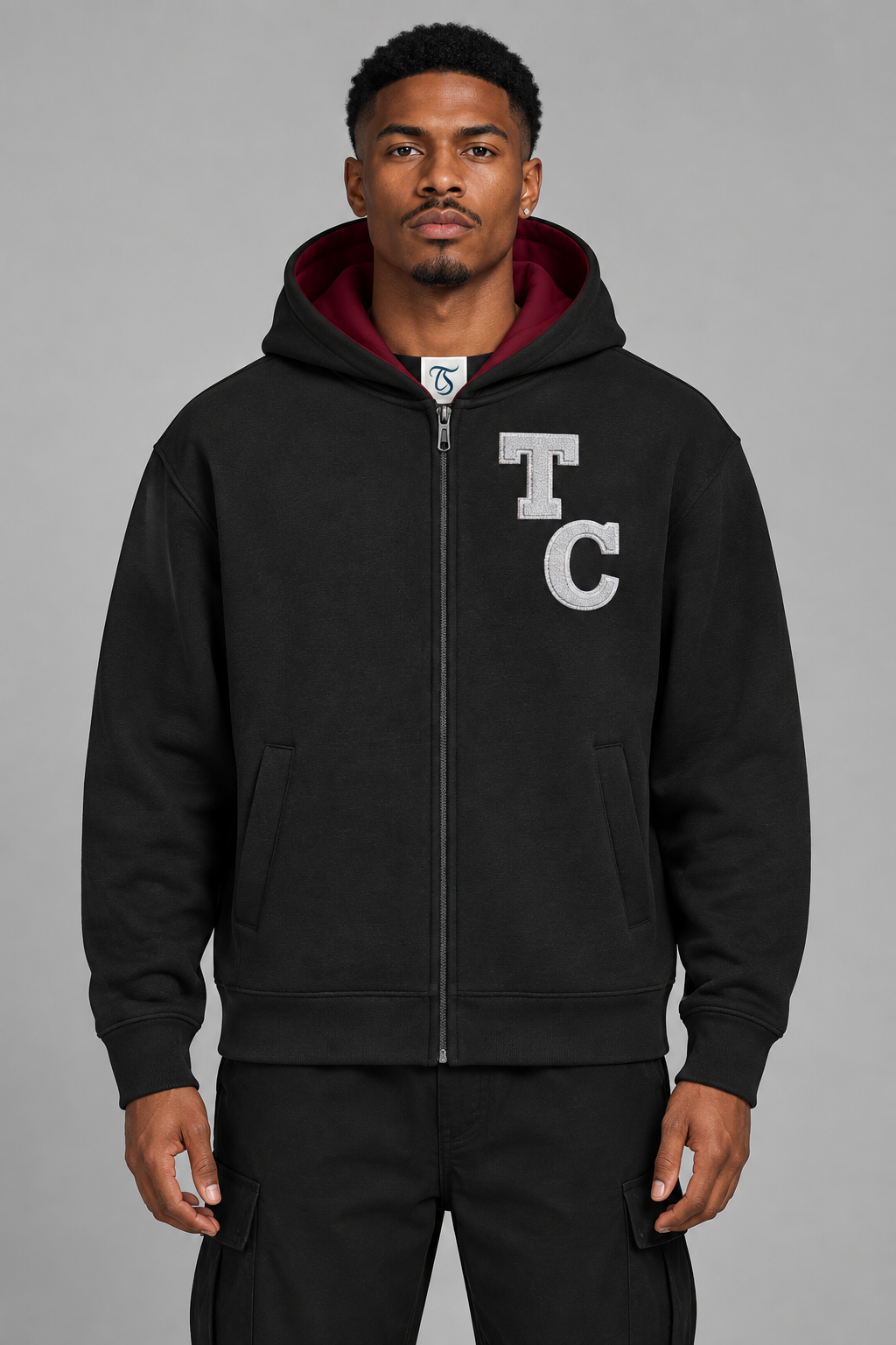 Model wearing black The Crew B-Ball full zip hoodie, front view; print is illustrative