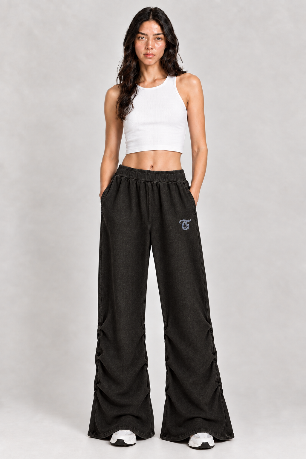 Female model wearing black Leo vintage wash ruched sweatpants with TS logo, front view