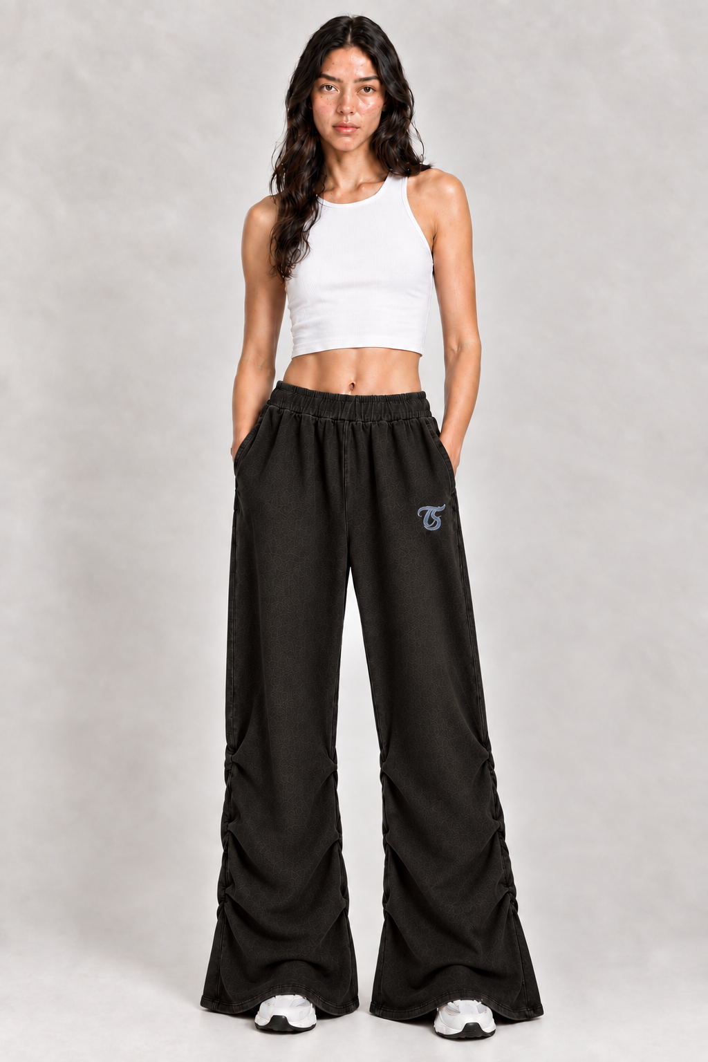 Female model wearing black Virgo vintage wash ruched sweatpants with TS logo, front view