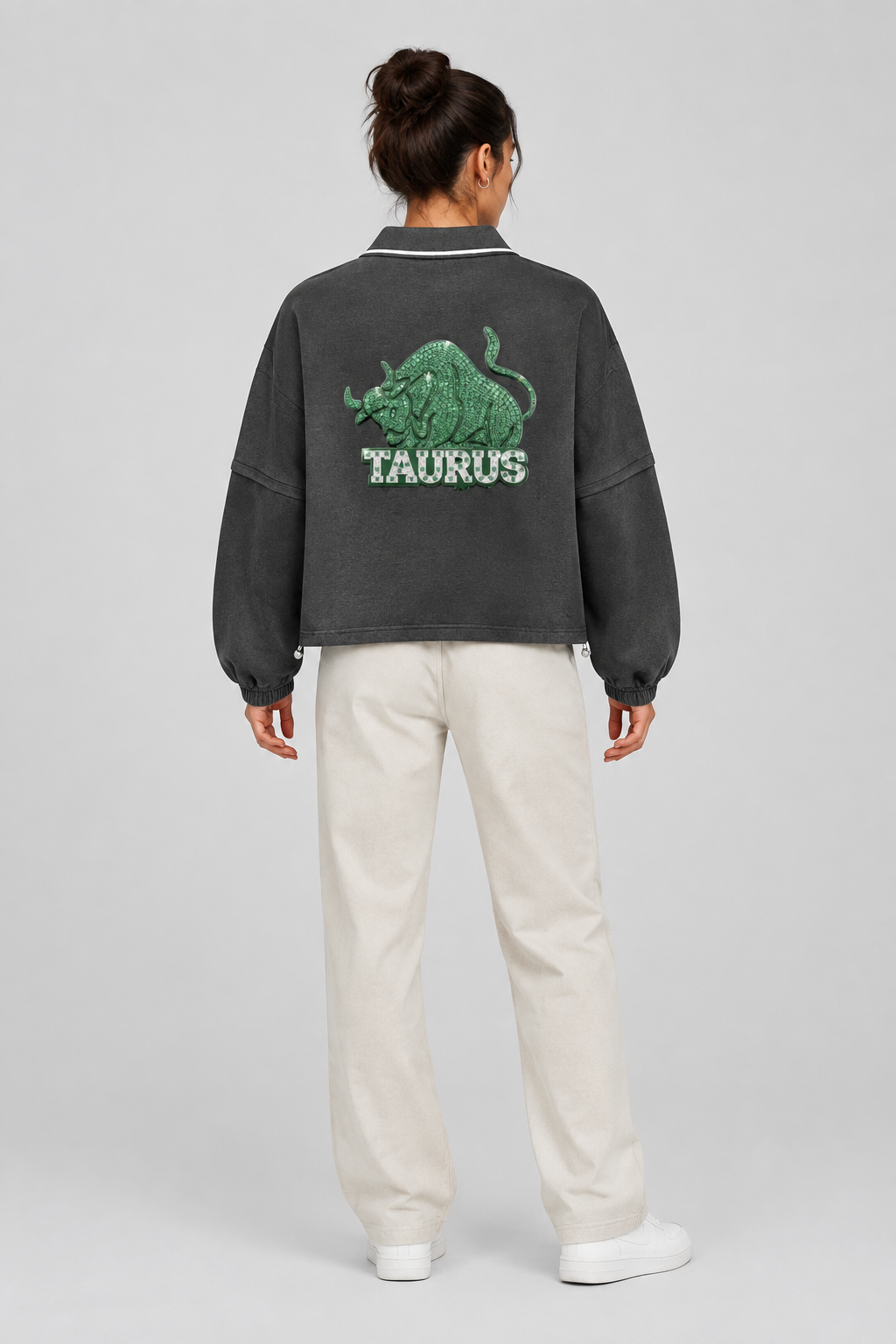 Female model wearing Taurus boxy collared detachable sweatshirt with bull artwork, back styling view; illustrative image