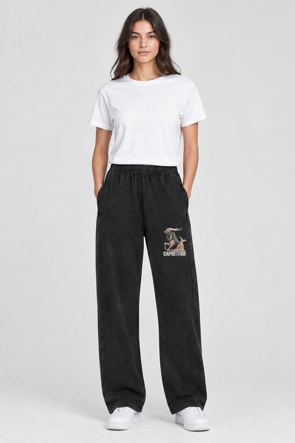 Female model wearing black Capricorn mineral wash straight sweatpants, Capricorn front thigh design; illustrative print