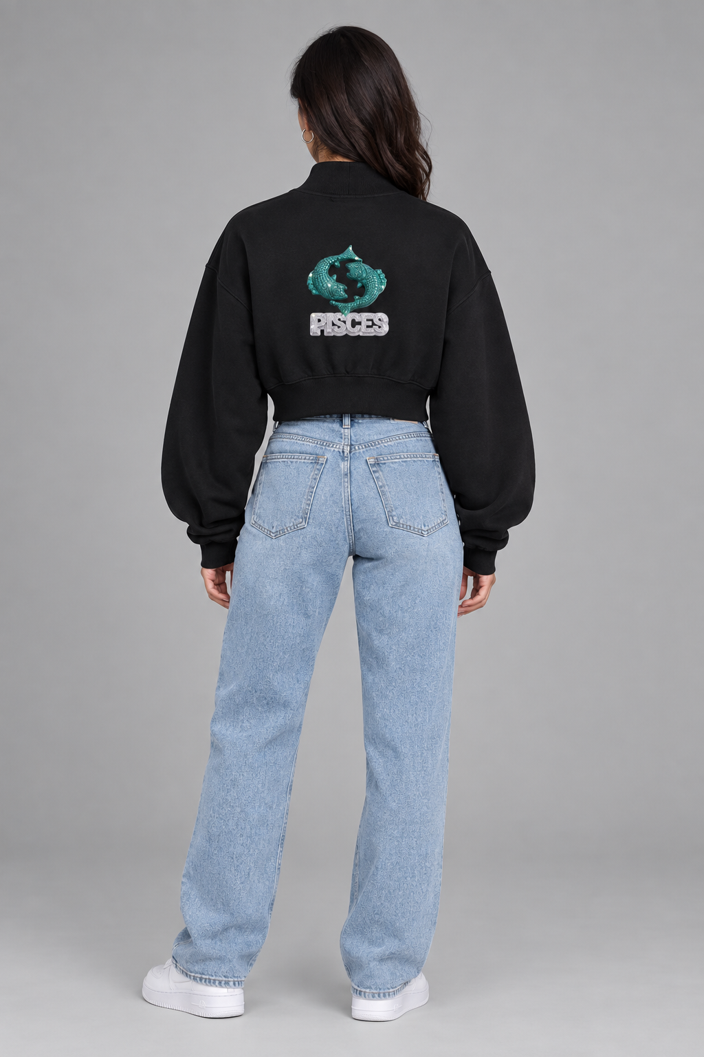 Female model wearing black Pisces women's crop mock neck sweatshirt, back view with Pisces fish artwork; illustrative print