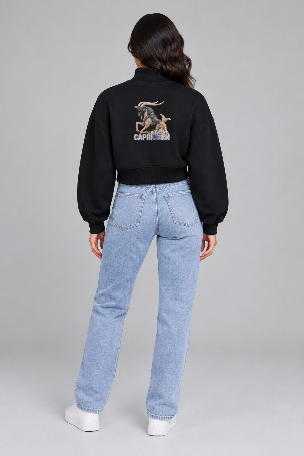 Female model in black Capricorn women's crop mock neck sweatshirt, back Capricorn goat design; illustrative print