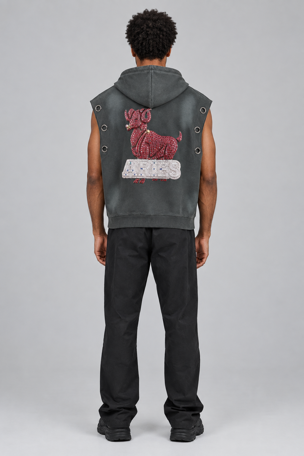 Model wearing Aries vintage wash sun fade sleeveless hoodie, back view with ram artwork; illustrative styling photo