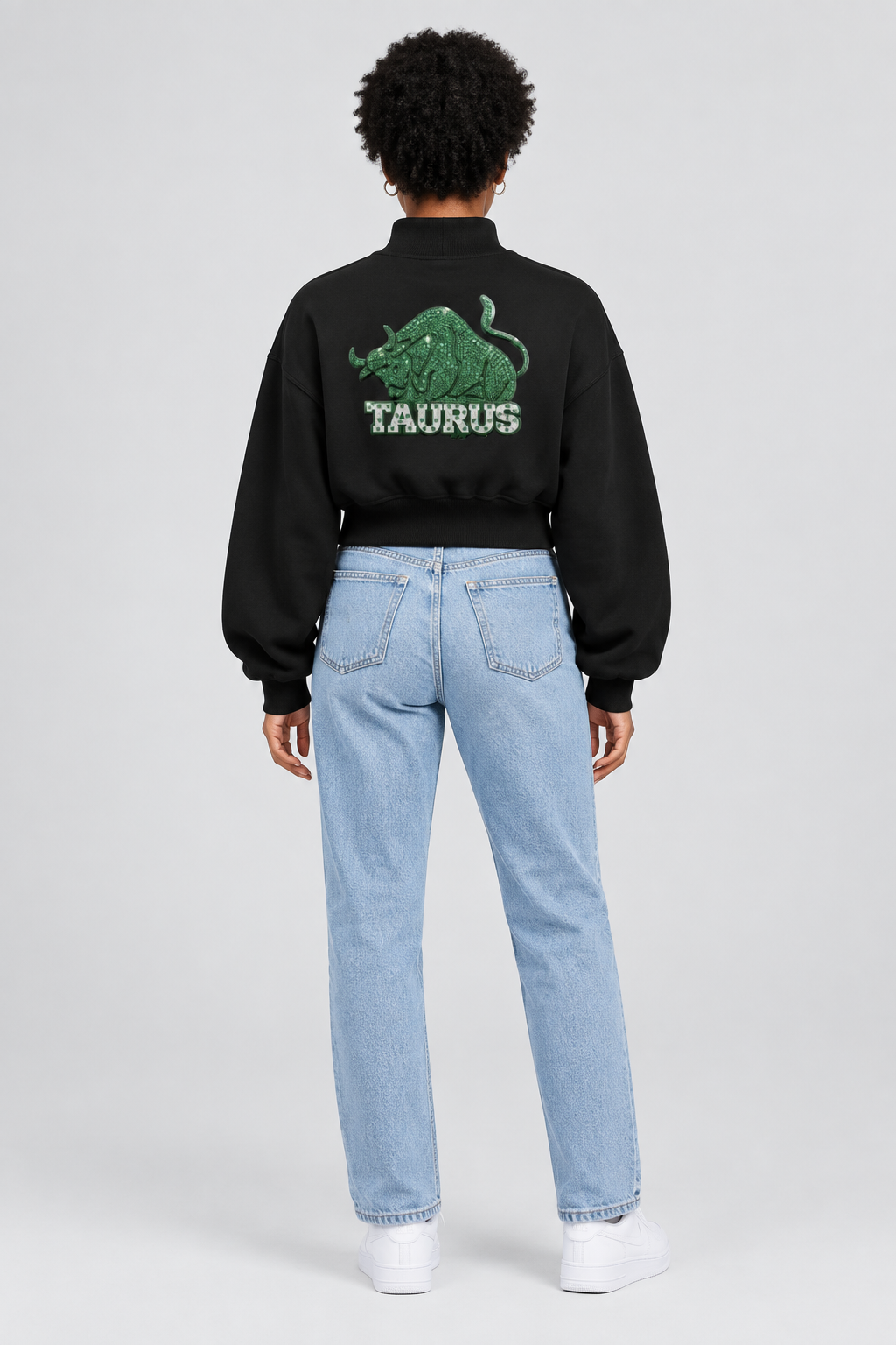 Female model in black Taurus women's crop mock neck sweatshirt, back with Taurus design; illustrative print