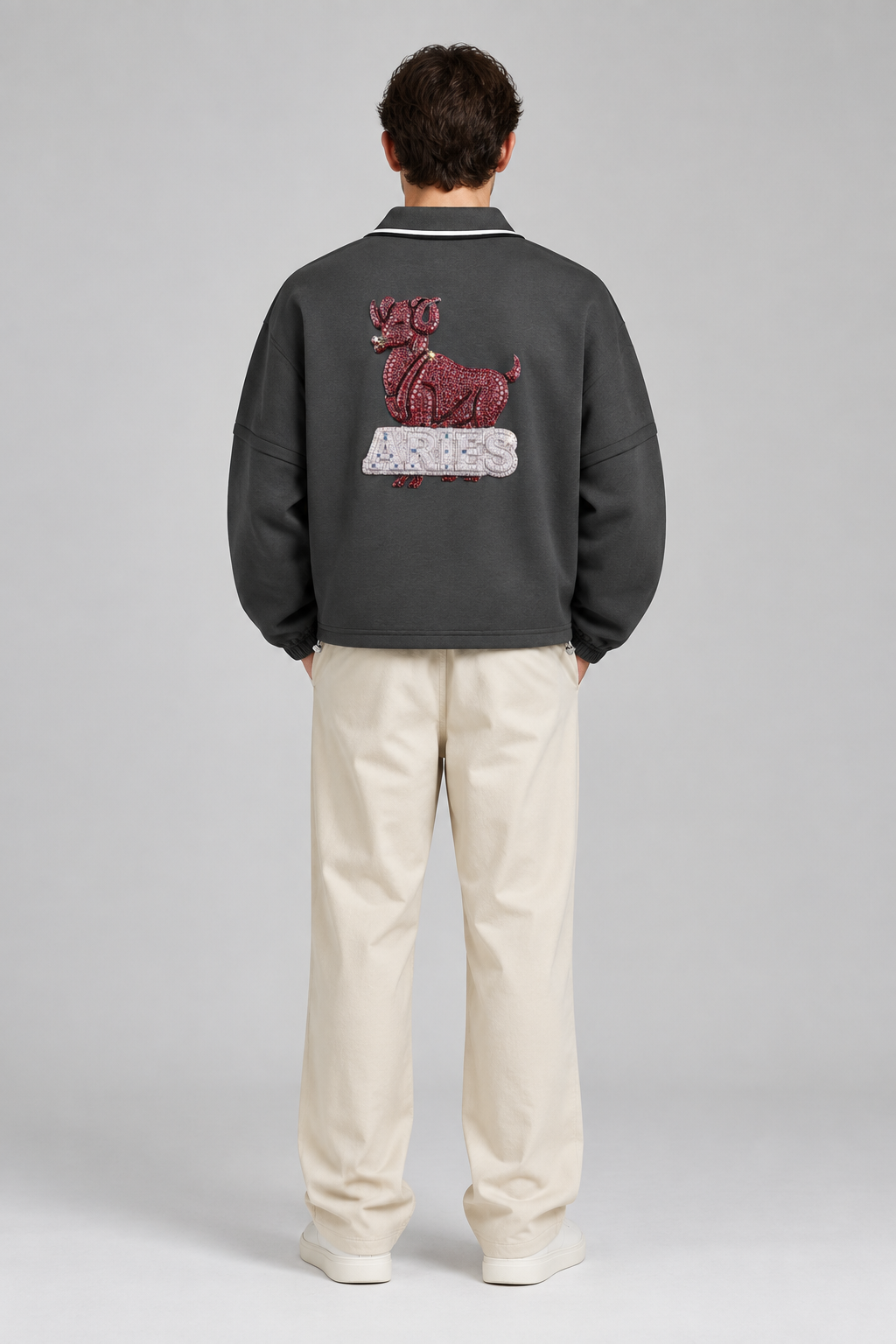 Model wearing Aries unisex boxy collared detachable sweatshirt with ram artwork, back view; illustrative styling image
