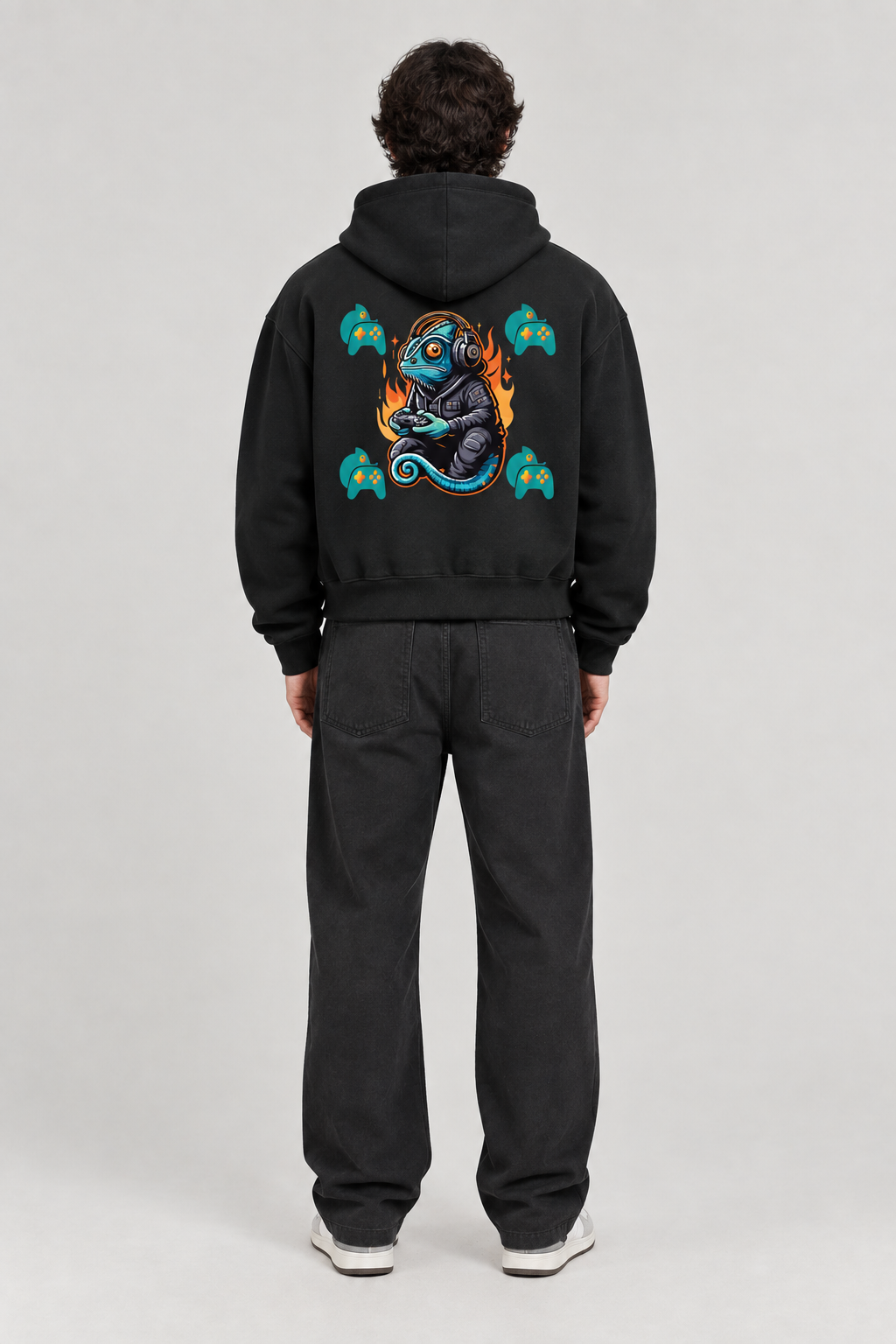 Back view of model wearing black fleeced full-zip boxy hoodie with colorful gaming lizard artwork