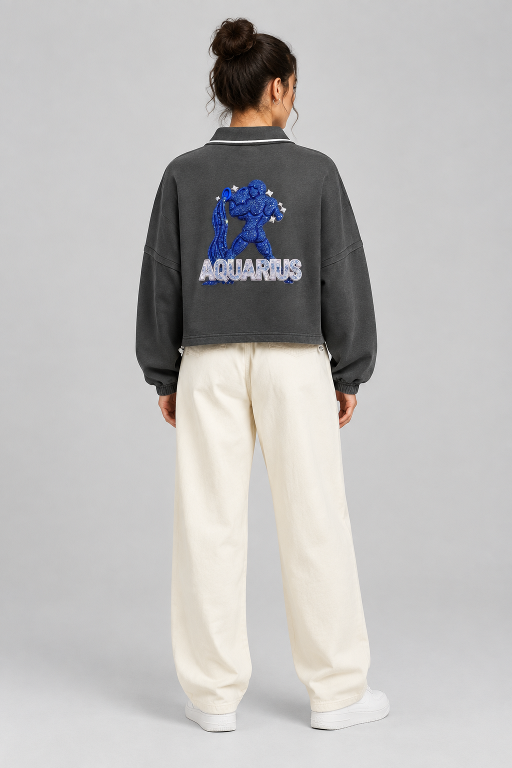 Female model wearing Aquarius unisex boxy collared detachable sweatshirt with water-bearer artwork, back view; illustrative styling image