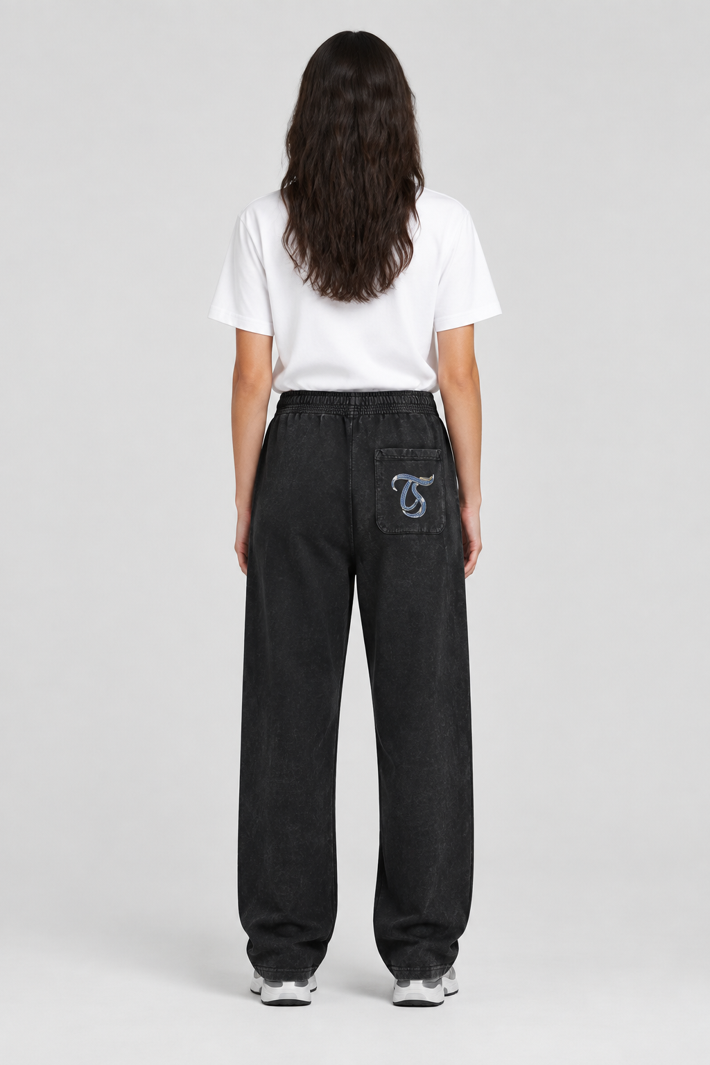 Female model wearing black Virgo mineral wash straight sweatpants, back TS pocket mark; illustrative print