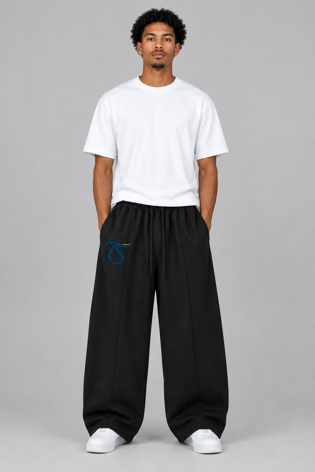 Model wearing black heavyweight wide leg panel sweatpants, front with TS mark; illustrative styling photo