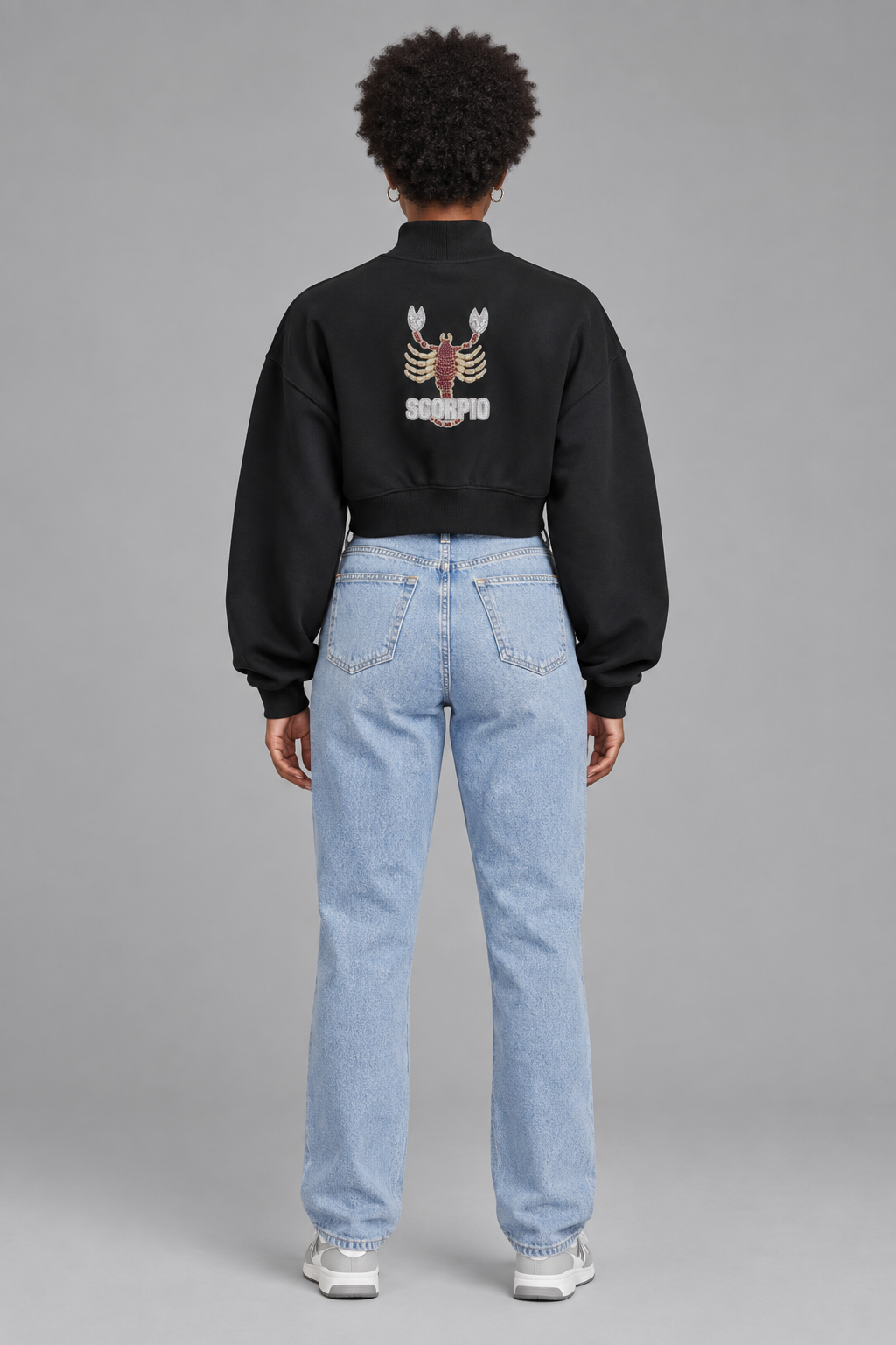 Female model in black Scorpio women's crop mock neck sweatshirt, back Scorpio design; illustrative print