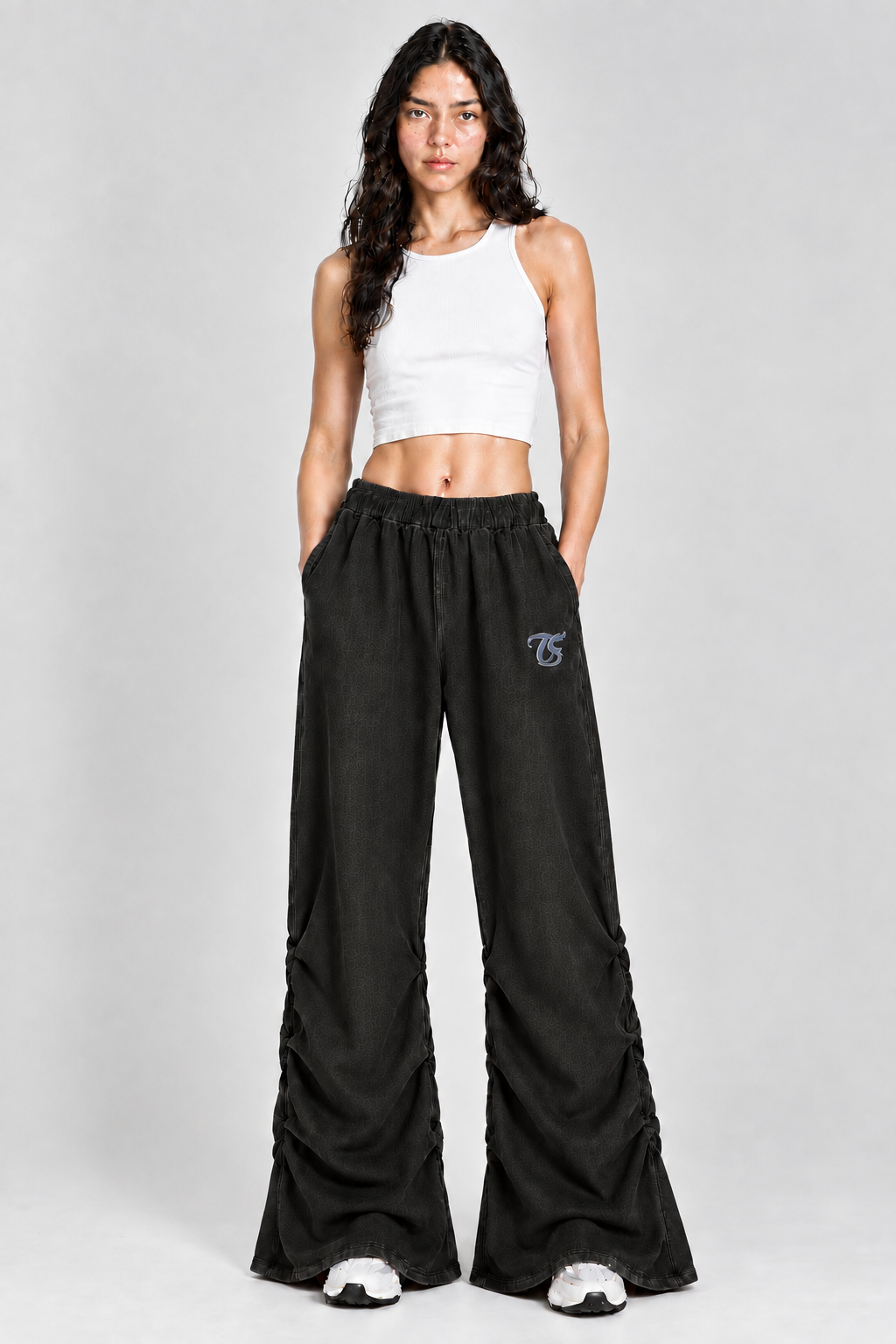 Female model wearing black Pisces vintage wash ruched sweatpants with TS logo, front view