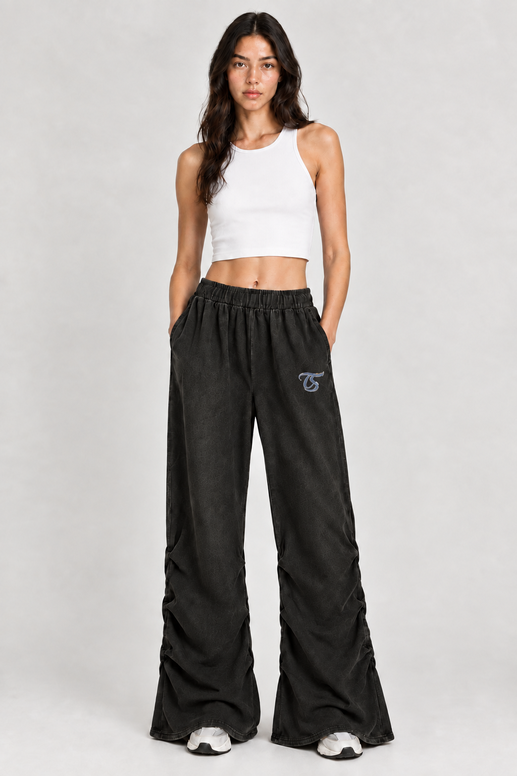 Female model wearing black Taurus vintage wash ruched sweatpants with TS logo, front view