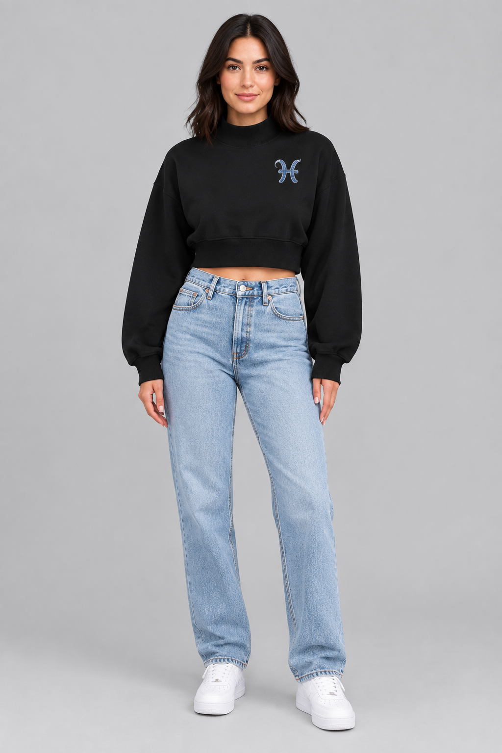 Female model wearing black Pisces women's crop mock neck sweatshirt, front view with Pisces chest symbol; illustrative print