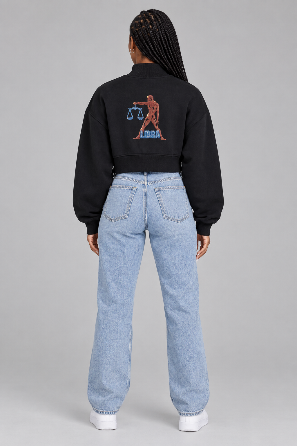 Female model in black Libra women's crop mock neck sweatshirt, back with figure, scales and LIBRA artwork; illustrative print