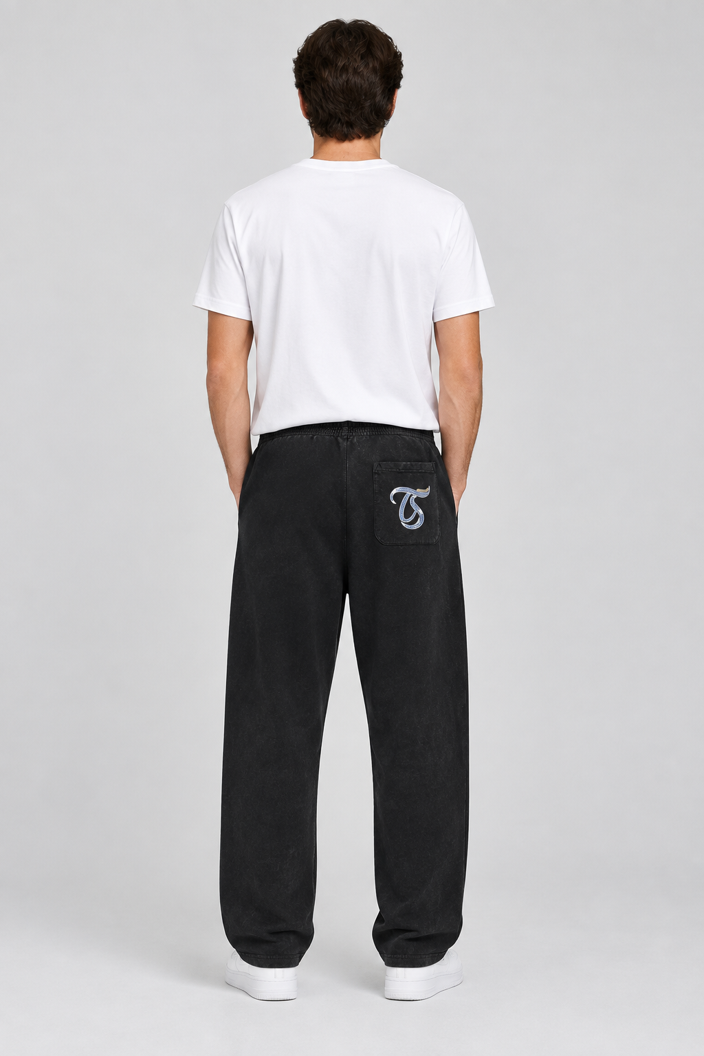 Male model wearing black Libra mineral wash straight sweatpants, back TS pocket mark; illustrative print